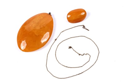 Lot 50 - A butterscotch amber double cabochon pendant and brooch