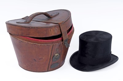Lot 695 - A black silk top hat; with a fitted leather hat box