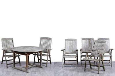 Lot 415 - A circular teak garden table; and a set of six folding teak garden chairs