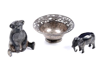 Lot 89 - An Edwardian silver elephant pattern pin cushion; a Chinese pin dish; and a bear pattern pepperette
