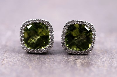 Lot 942 - A pair of peridot and diamond cluster earrings