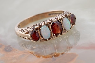 Lot 108 - An Edwardian-style opal and garnet ring