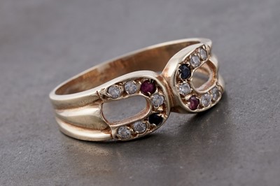 Lot 132 - A ruby and sapphire horseshoe pattern ring