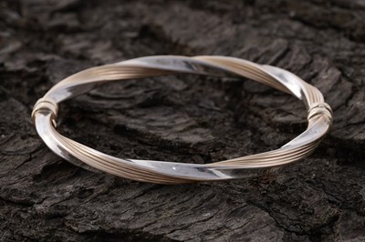 Lot 78 - A contemporary two-colour 9ct gold hinged bangle