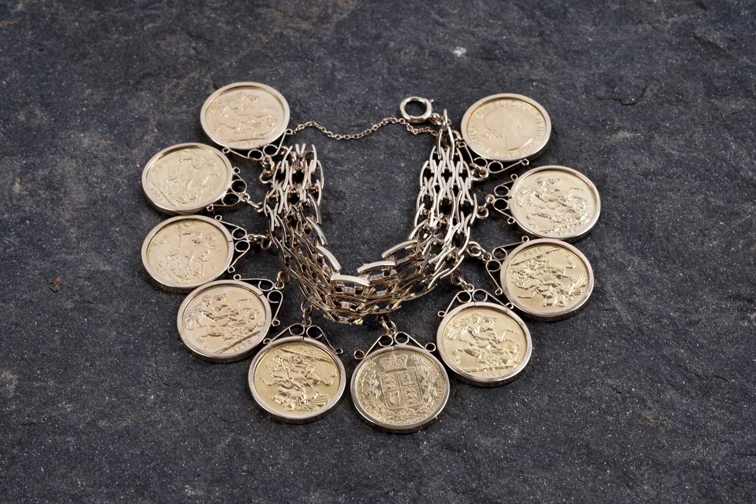 Lot 865 - A 9ct gold fancy-link bracelet set with ten gold sovereigns in fob mounts