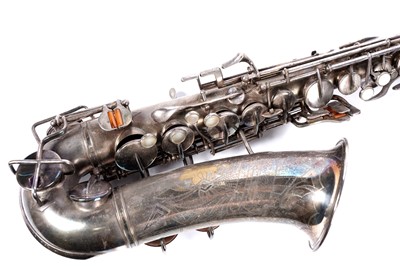 Lot 35 - A Buescher Aristocrat Low Pitch alto saxophone; and a painted plywood music bandstand