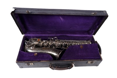 Lot 35 - A Buescher Aristocrat Low Pitch alto saxophone; and a painted plywood music bandstand