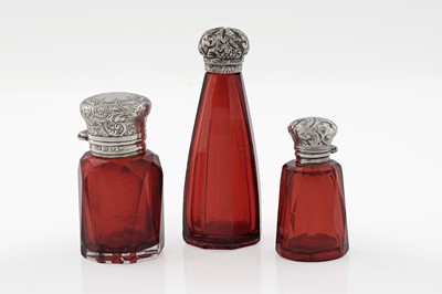 Lot 707 - Three late Victorian silver mounted ruby glass scent bottles