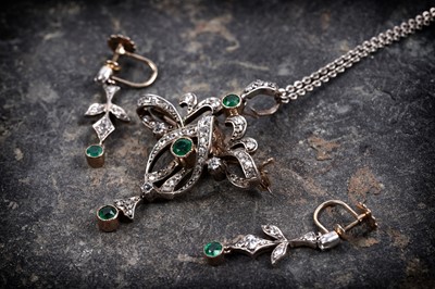 Lot 990 - An Edwardian emerald and diamond pendant/brooch and matching earrings