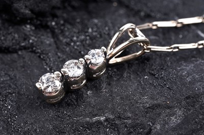 Lot 861 - A three stone diamond pendant