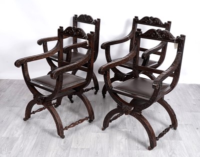 Lot 48 - A set of four 20th Century heavily carved hardwood Savonarola style ‘X’ framed armchairs