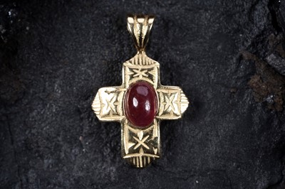 Lot 520 - A cruciform pendant set with a ruby cabochon