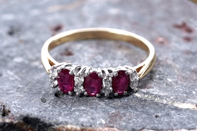 Lot 521 - A three stone ruby and diamond ring