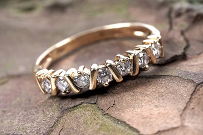 Lot 523 - A seven stone diamond half-hoop eternity ring