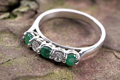 Lot 139 - A contemporary emerald and diamond half hoop eternity ring