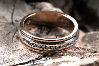 Lot 146 - A modern diamond set 9ct white and yellow gold band