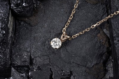 Lot 585 - A solitaire diamond pendant on chain