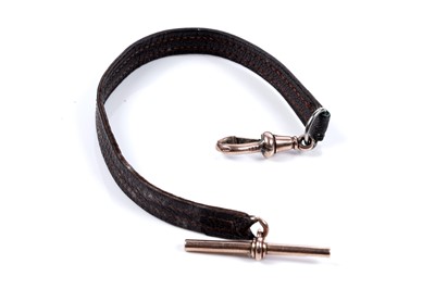 Lot 627 - An early 20th Century leather watch ribbon with rose gold T-bar and swivel