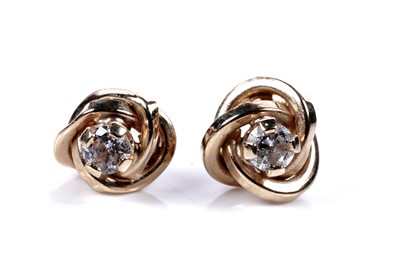 Lot 598 - A pair of diamond knot pattern stud earrings