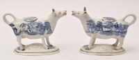 Lot 336 - Pair of blue and white cow creamers and covers,...