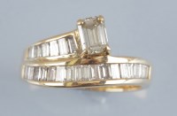 Lot 854 - A diamond ring, the main emerald-cut diamond...