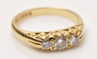 Lot 857 - A three stone diamond ring, the graduated...