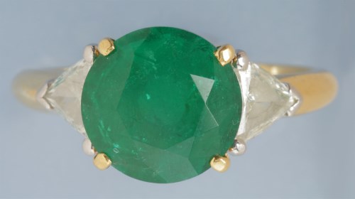 Lot 883 - An emerald and diamond ring, the circular...