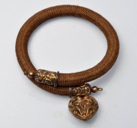 Lot 910 - A Victorian mourning bangle of plaited hair...