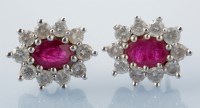 Lot 934 - A pair of ruby and diamond cluster earrings,...