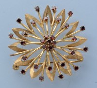 Lot 951 - A garnet and yellow metal star pattern brooch,...