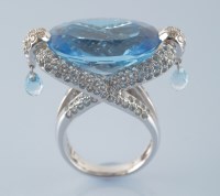 Lot 960 - A topaz and diamond dress ring, the oval facet...