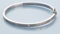 Lot 992 - A diamond set 18ct. white gold bangle, the...