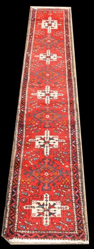 Lot 1046 - A Karajeh runner, with five medallions on red...