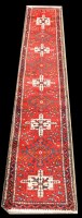 Lot 1046 - A Karajeh runner, with five medallions on red...