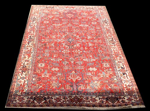 Lot 1053 - A Heriz carpet, the bold floral design on red...