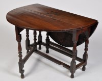 Lot 1219 - An 18th Century oak drop leaf table, the oval...