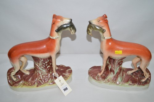 Lot 968 - A pair of Staffordshire greyhounds holding hares.