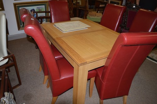 Lot 1291 - A solid oak extending dining table, one spare...