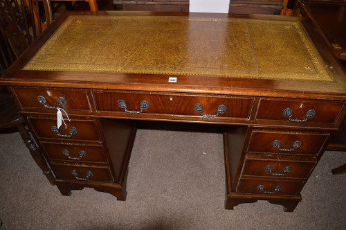 Lot 1332 - A reproduction mahogany kneehole desk with...