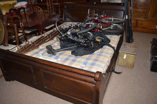 Lot 1379 - A stained oak king size sleigh bed, with...