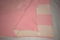 Lot 1131 - An early 20th Century Durham quilt, pink and...