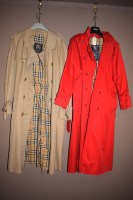 Lot 1219 - Two Burberry trench coats; one in red; the...