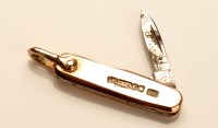 Lot 729 - A 9ct. yellow gold fruit knife pattern charm,...