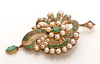 Lot 770 - An emerald and pearl pendant/brooch, of...