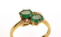 Lot 790 - An emerald and diamond ring, set with two oval...