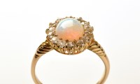 Lot 811 - An opal and diamond cluster ring, the oval...