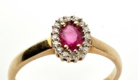 Lot 831 - A ruby and diamond cluster ring, the oval...