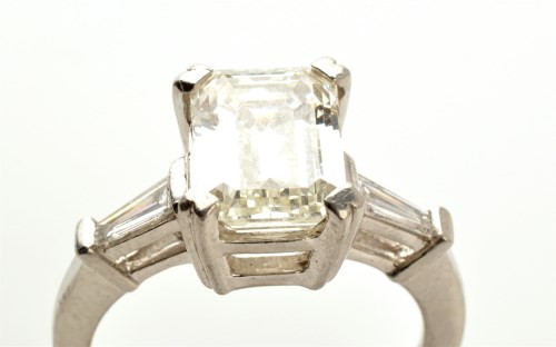 Lot 843 - A diamond ring, the emerald cut diamond corner...