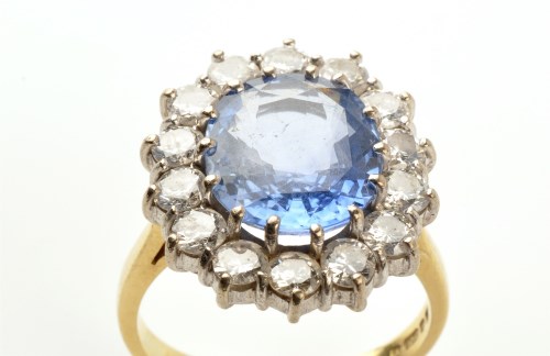 Lot 849 - A sapphire and diamond cluster ring, the...