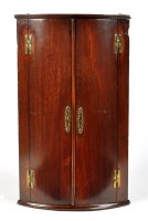 Lot 992 - A George III mahogany bowfront hanging corner...